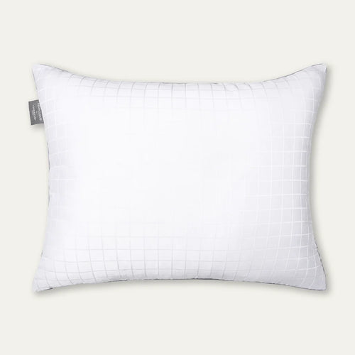 White pillow with grid pattern on a light gray background